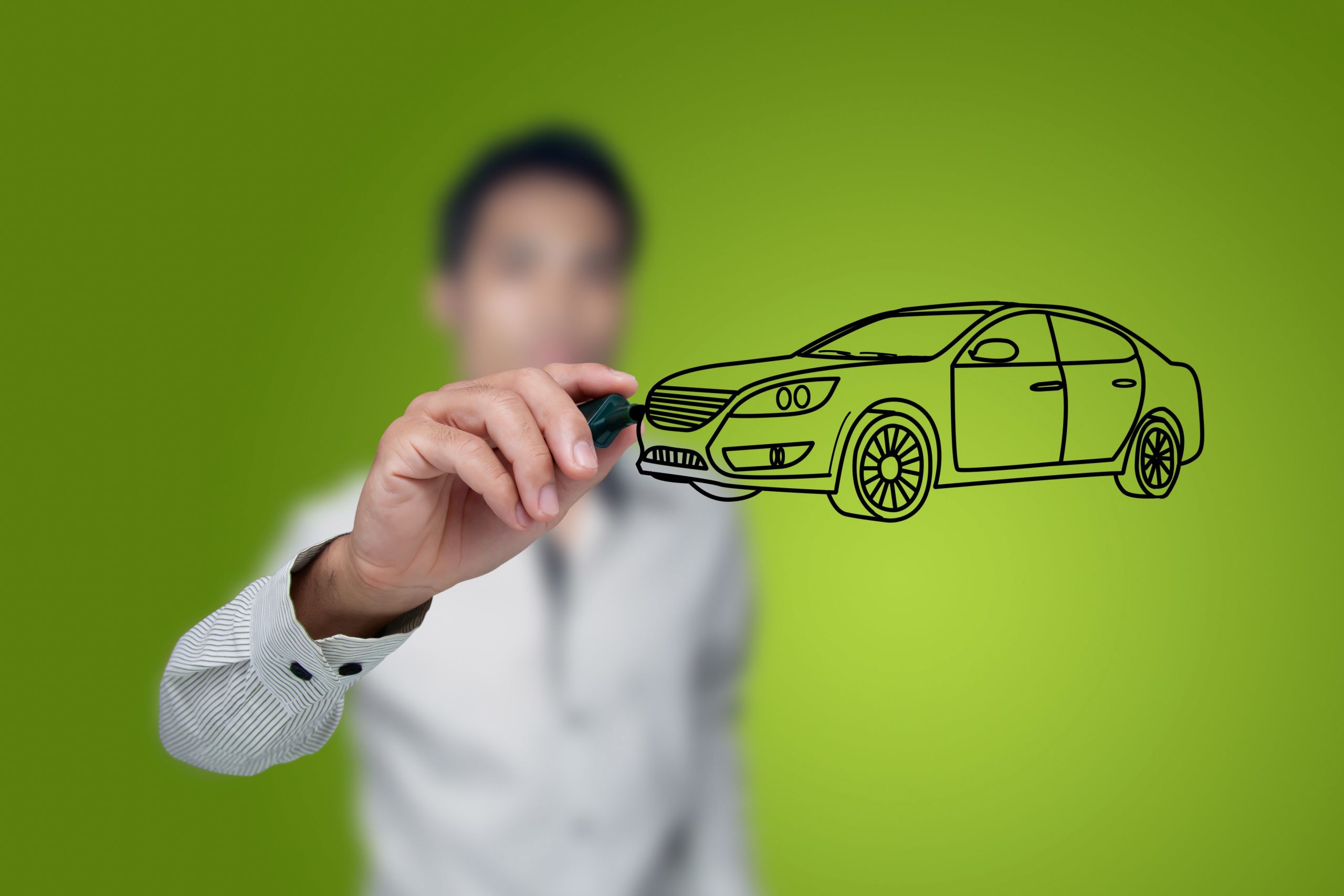 Image of a man drawing an outline of a black car on glass with green background